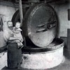 1923: Kollergang mit Sandsteinwalzen und Sandsteinteller, davor Ölmüller und Tochter des Mühlenbesitzers Carl Michael Fuchs.